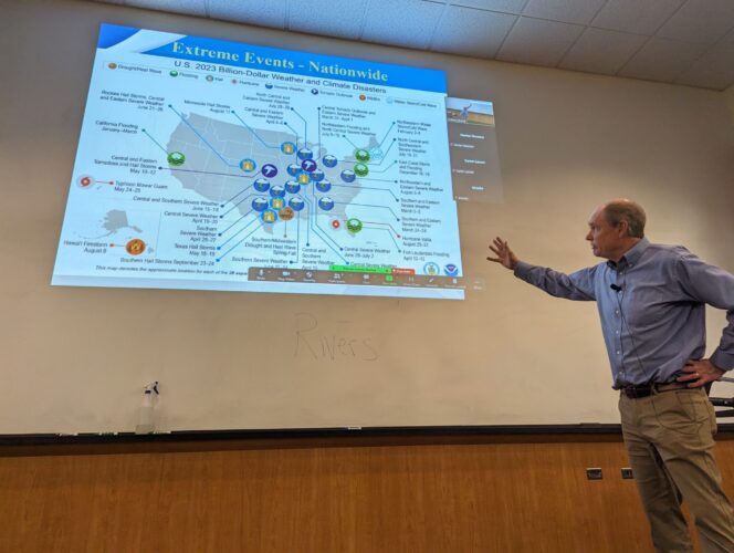 Photo of Jay Breidenbach, a meteorologist at NOAA's NWS Boise office, lecturing in front of a projector image.