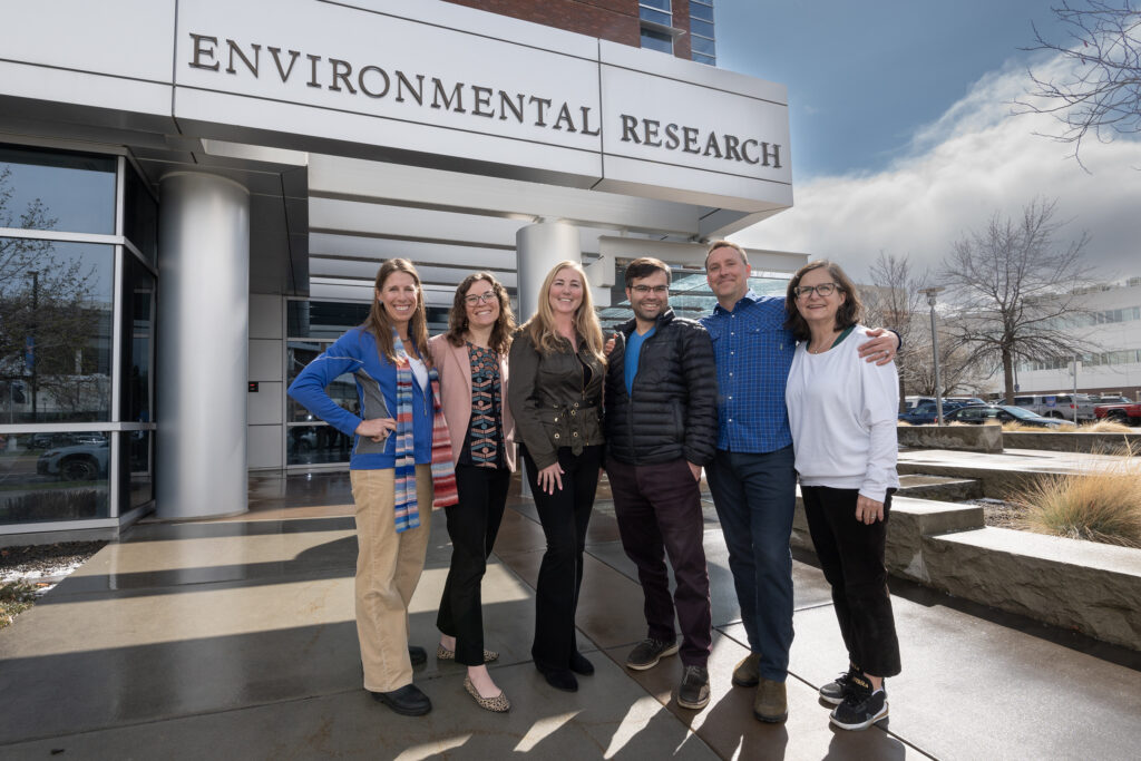 group of six people stand outside Boise State's environmental research building