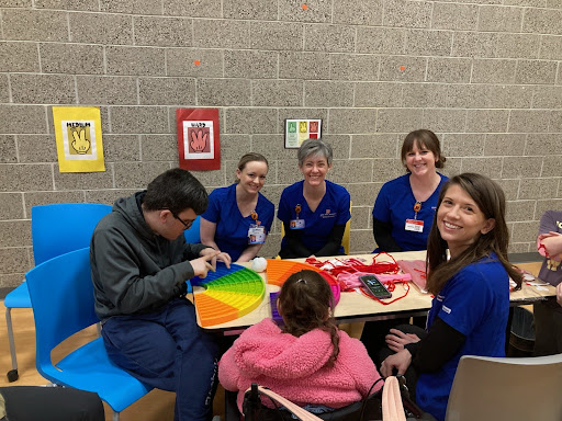 People working on an activity with nurses helping them