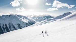 2 people hiking in snow covered mountains