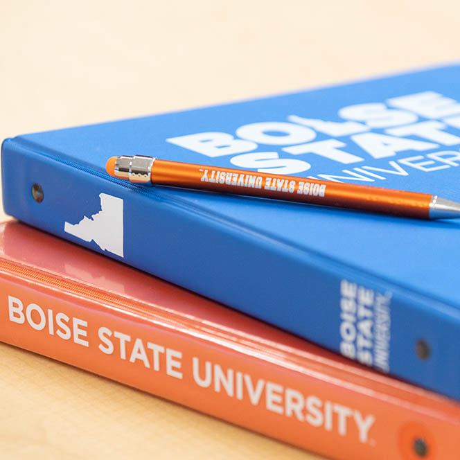 Boise State branded notebooks lie on a table