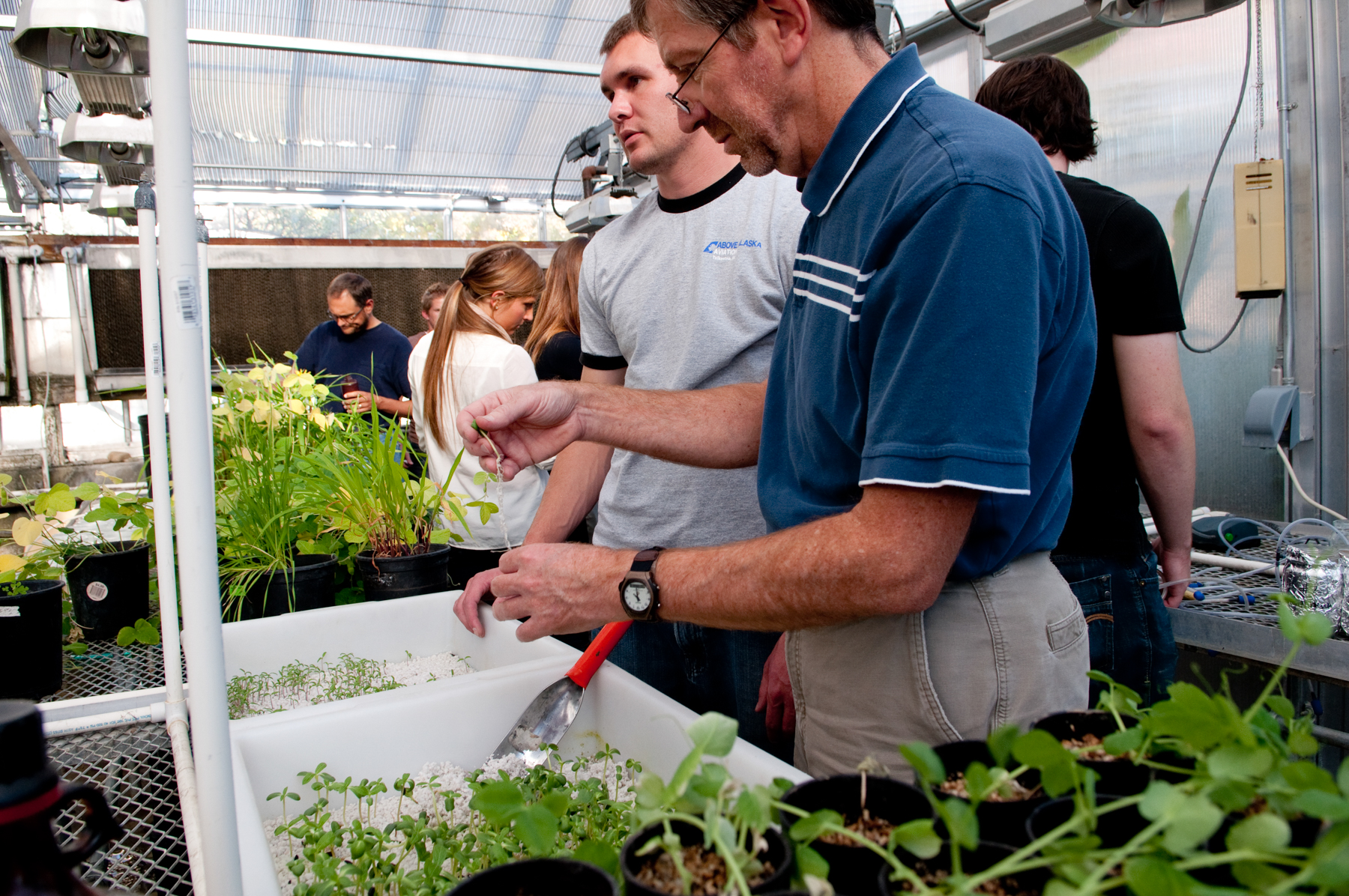 Marcelo Serpe in greenhouse with students