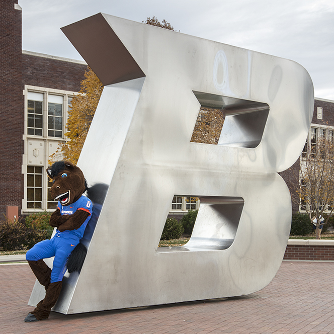 Buster Bronco posing at the B statue on campus