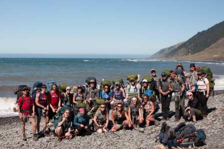 Group backpacking phot in front of the ocean.