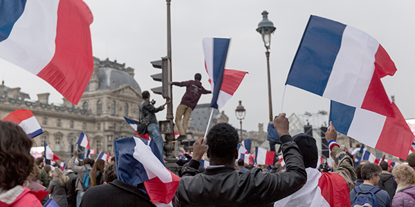 Photo of people waving french flags at a rally