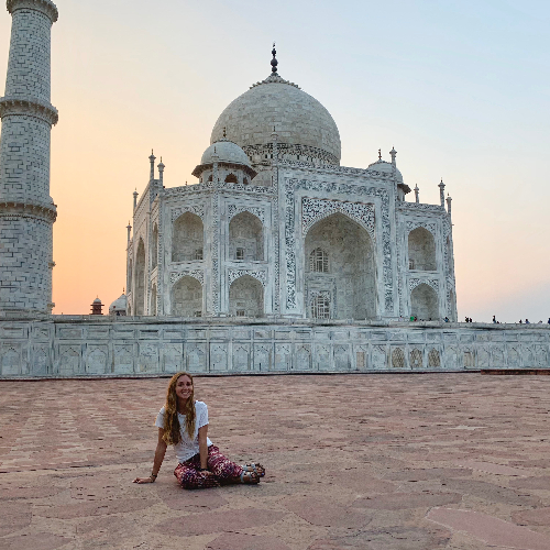 Student sitting in front of the Taj Mahal at sunset