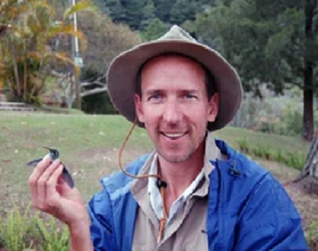 David Anderson holding a hummingbird in the field