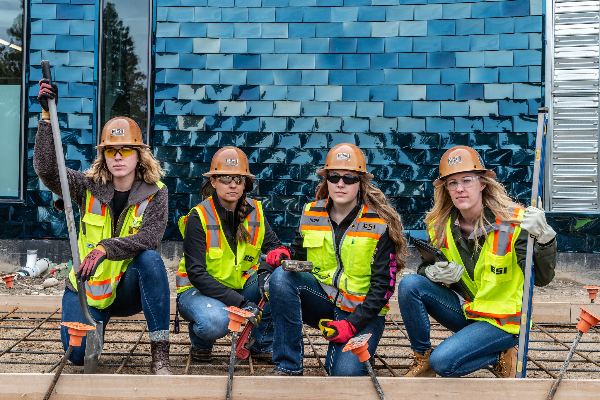 four Boise State construction management students wearing hats and vests