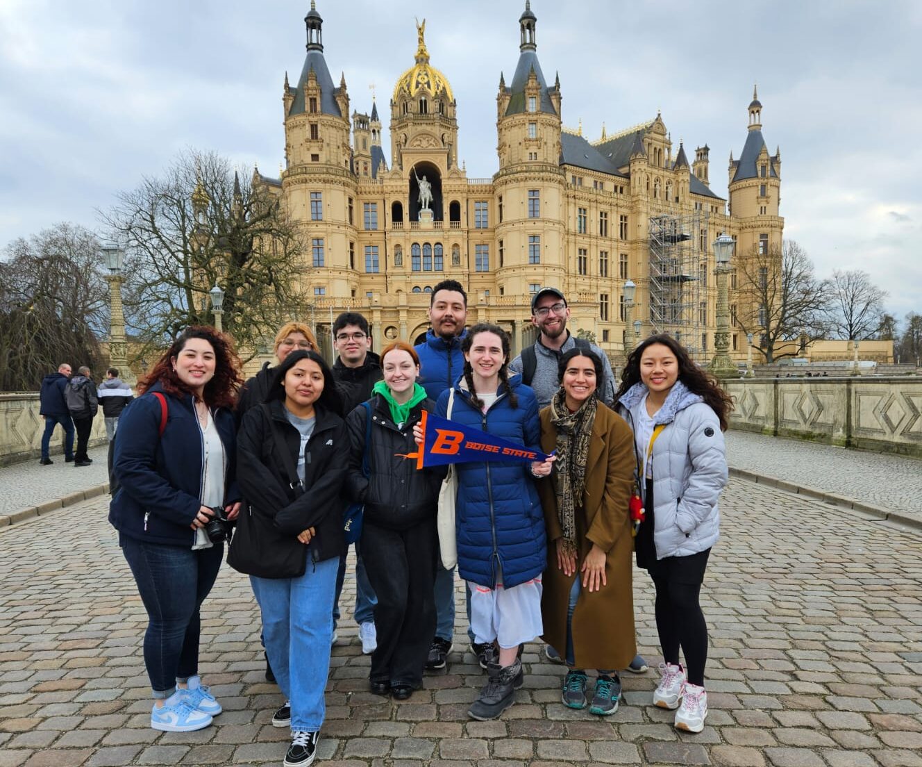 Tori (middle holding a BSU flag) with friends in front of a castle in in Schwerin, Germany. Photo Credits: Tori Simon
