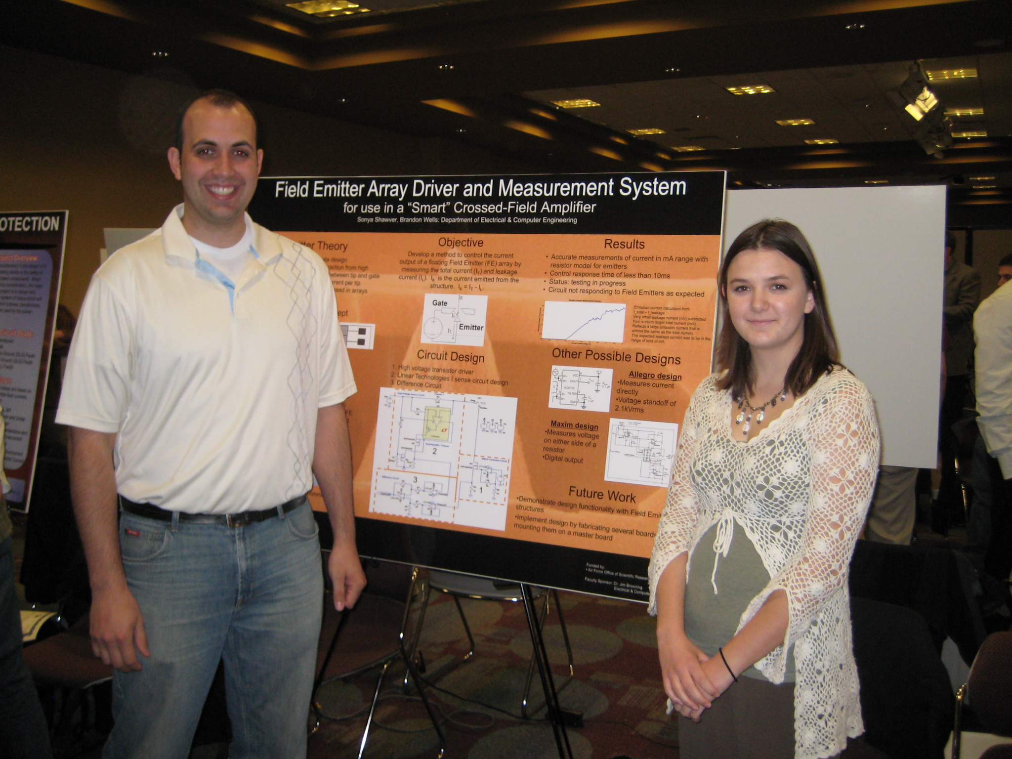 two people at an undergraduate research showcase standing in front of a poster