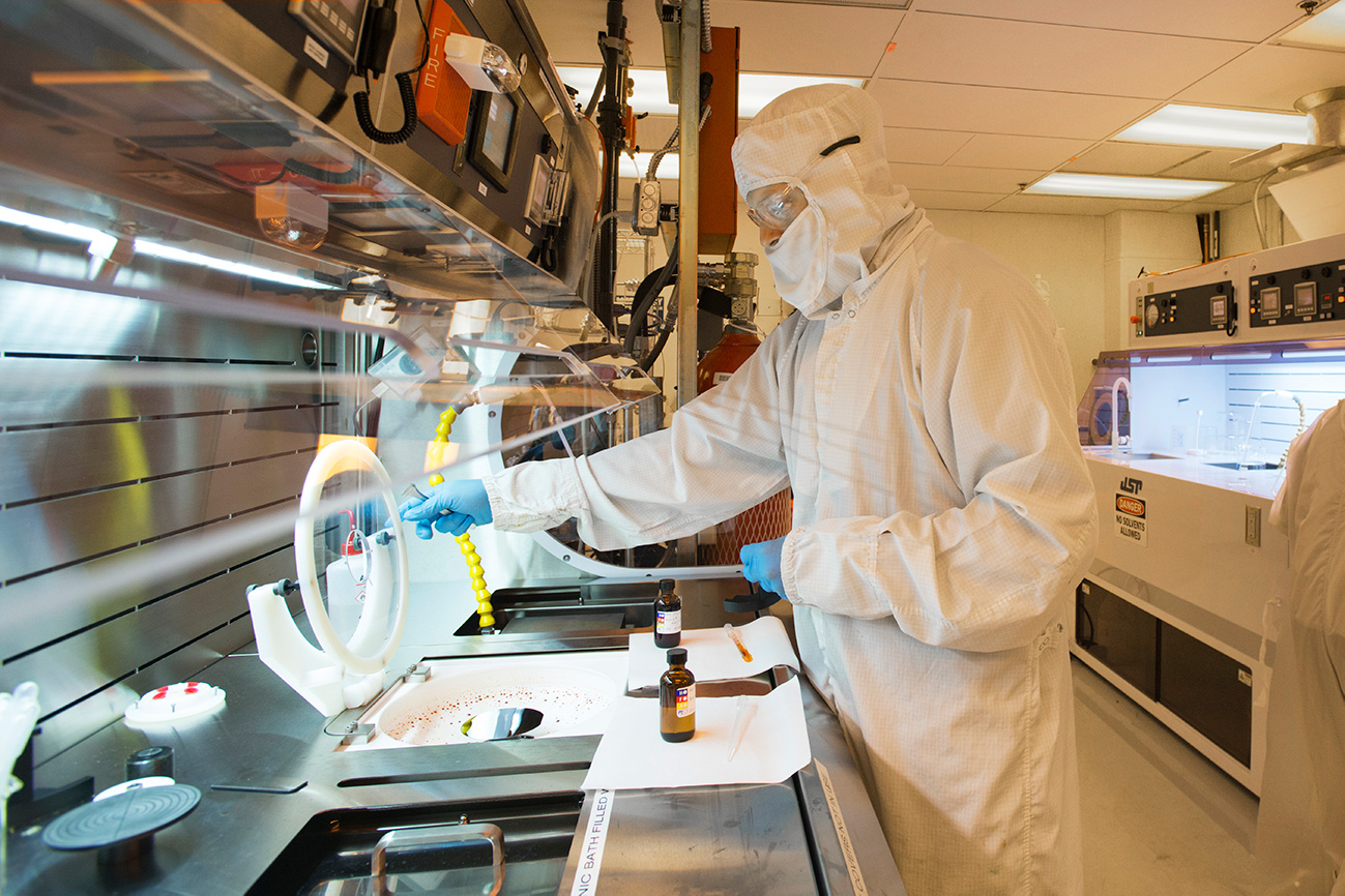 man dressed in protective clothing in a lab