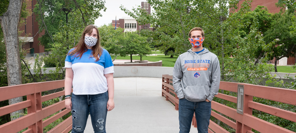 a female students and male student wearing face masks on campus