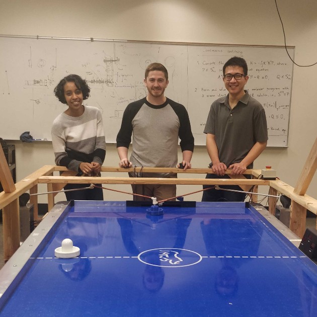 students with robot controlled air hockey table