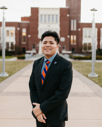 Isaac Celedon standing in front of a brick building