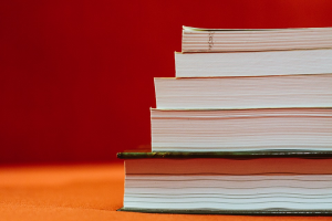 Picture of 5 stacked books with orange background 
