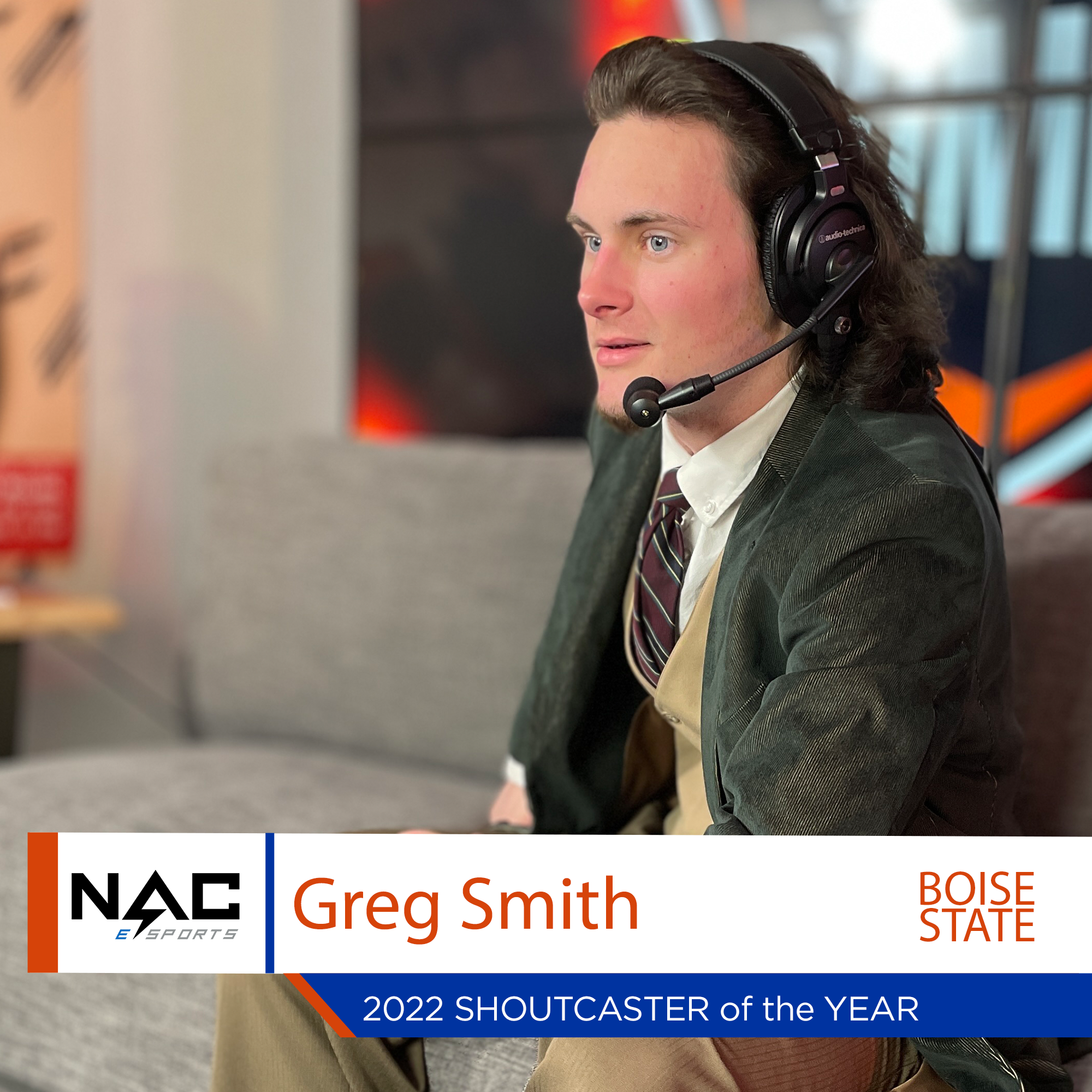Greg sits on couch wearing a headset with microphone