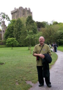 Gerry Bryant standing in front of castle remains in Ireland