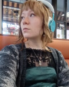 photo of Cora Lee Oxley looking into the distance and wearing headphones