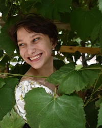Megan Slusarewicz posing surrounded by foliage