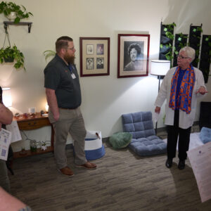 A faculty member tells visitors about the features in the selfcare room. 