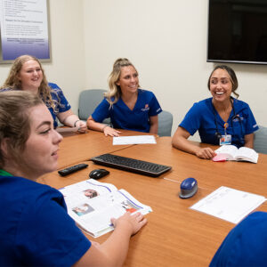 Nursing students talk in a simulation debriefing room