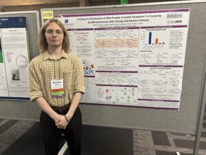 Photo of Matthew Lindley standing in front of his research poster