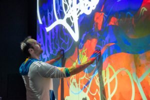 Konrad Meister interacting with the 3D chemical structure touchscreen displays in the Boise State Luminary