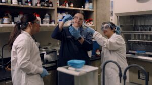 Mia Rheede looking over samples in the lab with two lab assistants