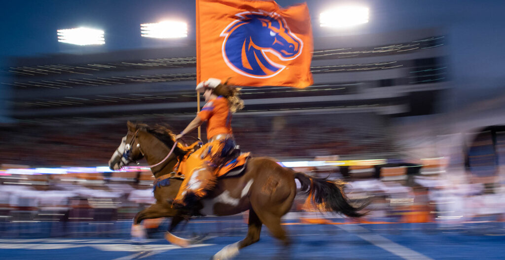Bronco Girl riding horse on to Blue Turf