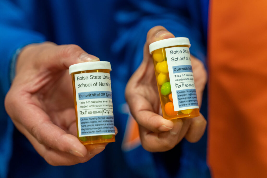 A close up of fake pill bottles with prescription labels that read 