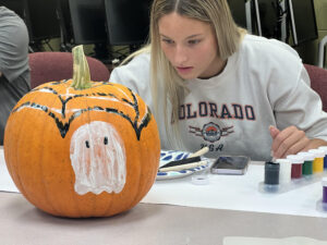 student points ghost on pumpkin