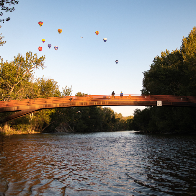 Boise, Idaho River, Friendship Bridge, and multiple hot air balloons taking off