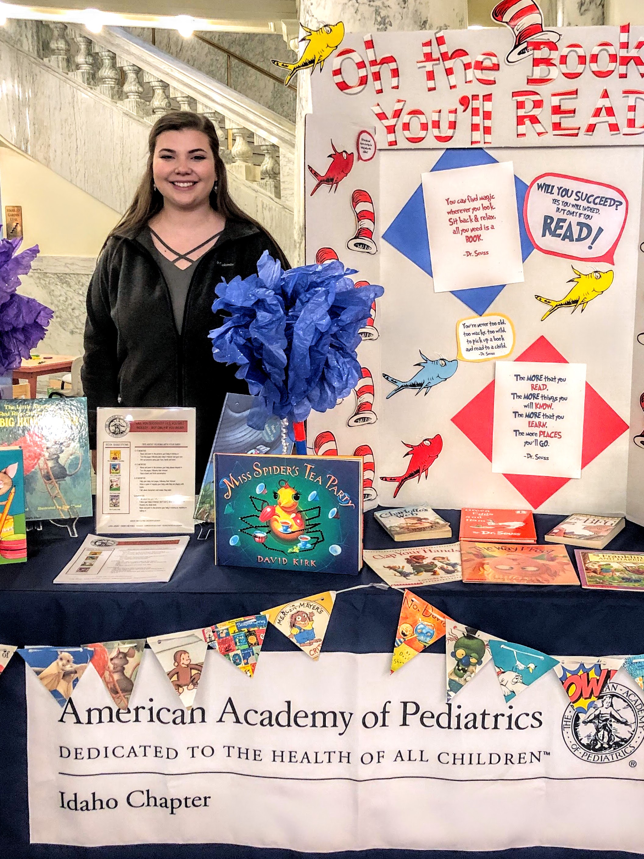 Dani Beaupre standing behind an American Academy of Pediatrics booth