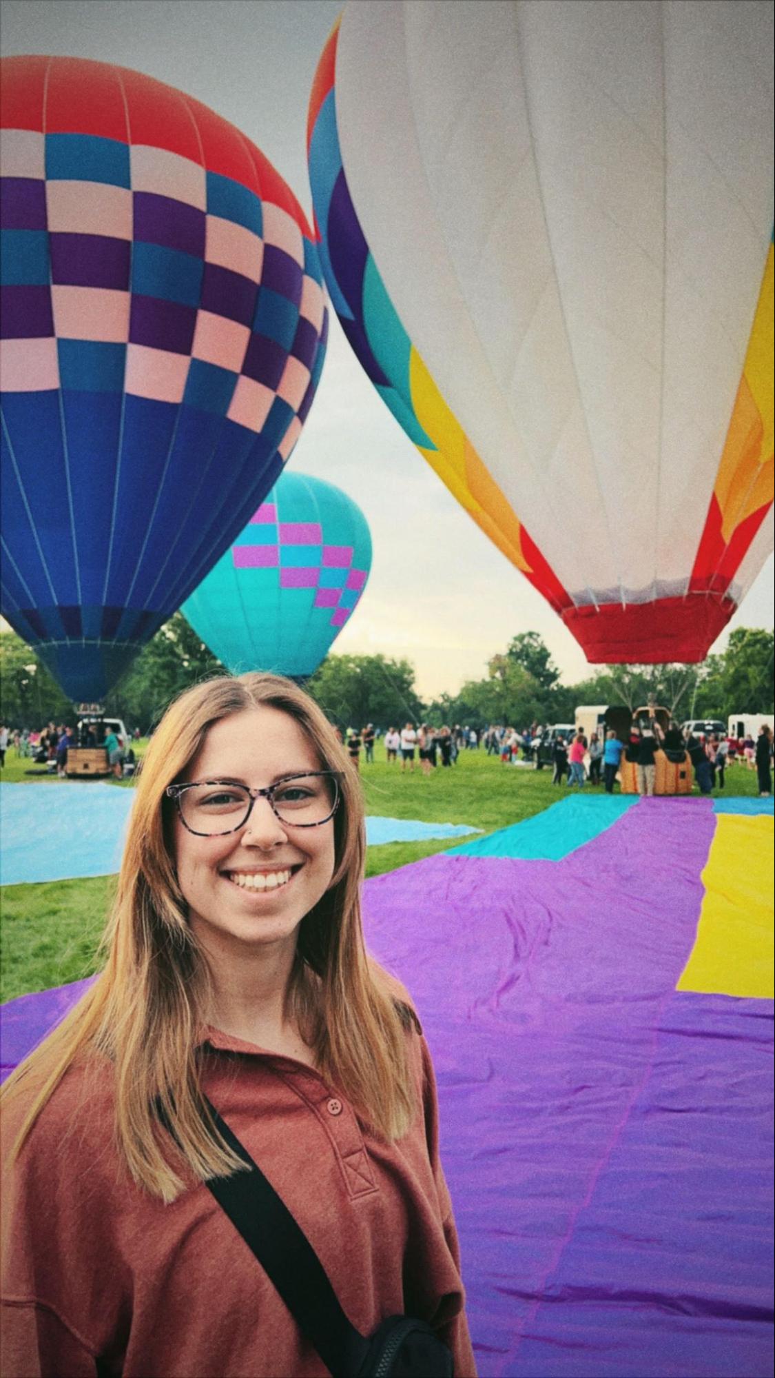 Maddie Mesher in front of hot air balloons